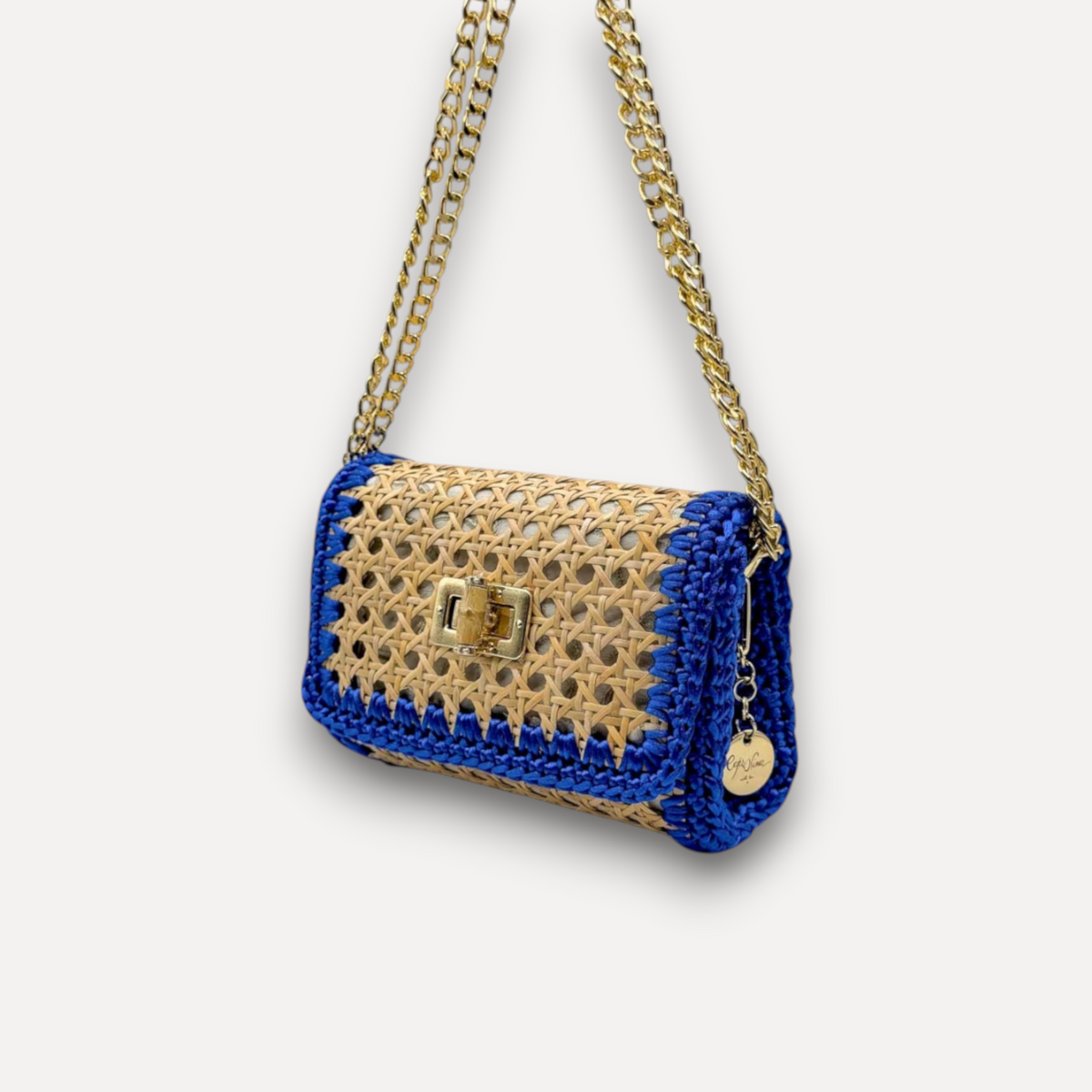 Borsa CapriNina Vienna in paglia intrecciata naturale con dettagli blu e tracolla a catena dorata