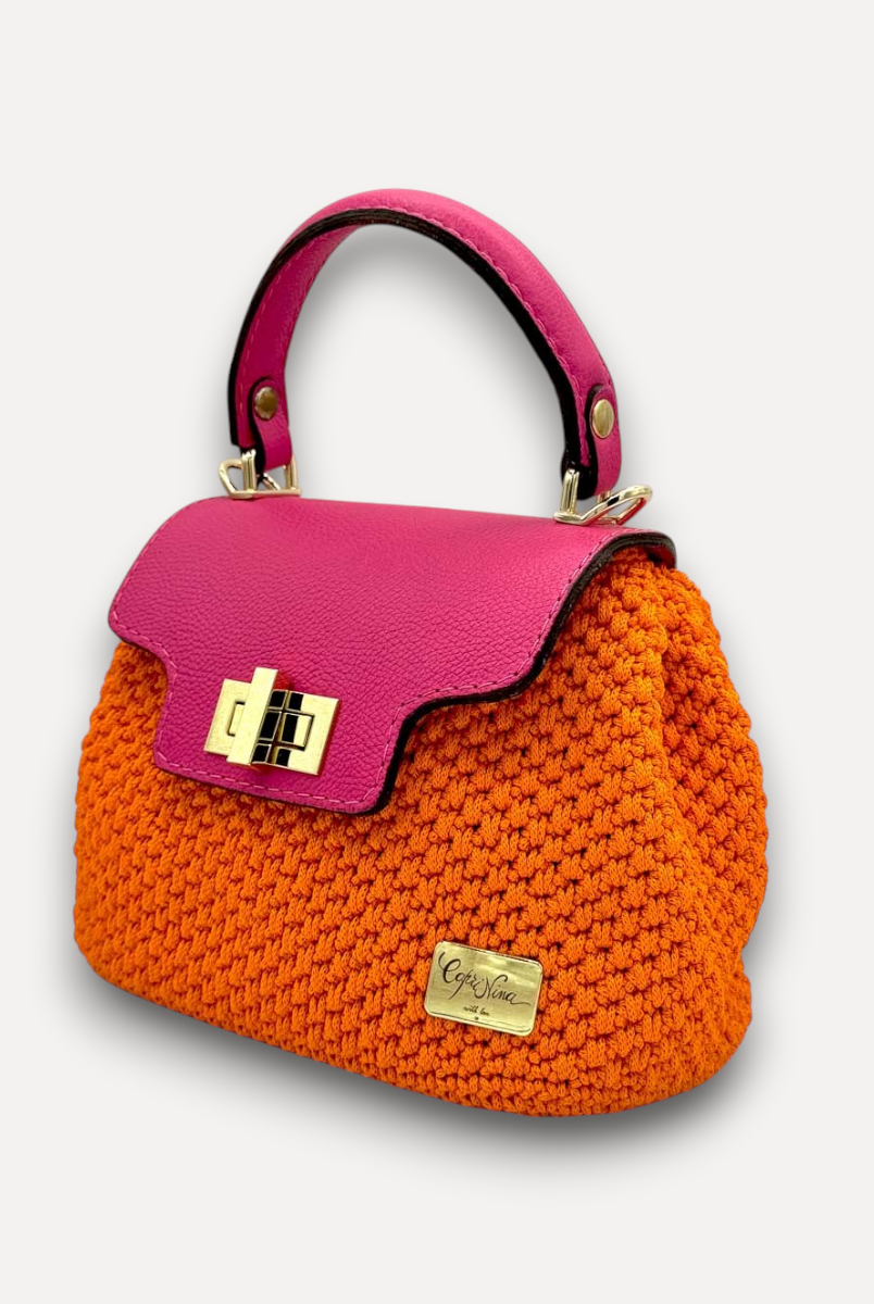 Borsa a mano CapriNina Capriccio in uncinetto arancione con patta in pelle fucsia e chiusura a girello dorata