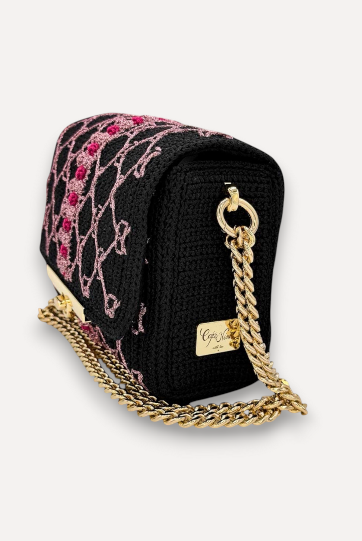Borsa CapriNina fatta a mano all'uncinetto nera con ricami rosa, chiusura a incastro e catena dorata regolabile.