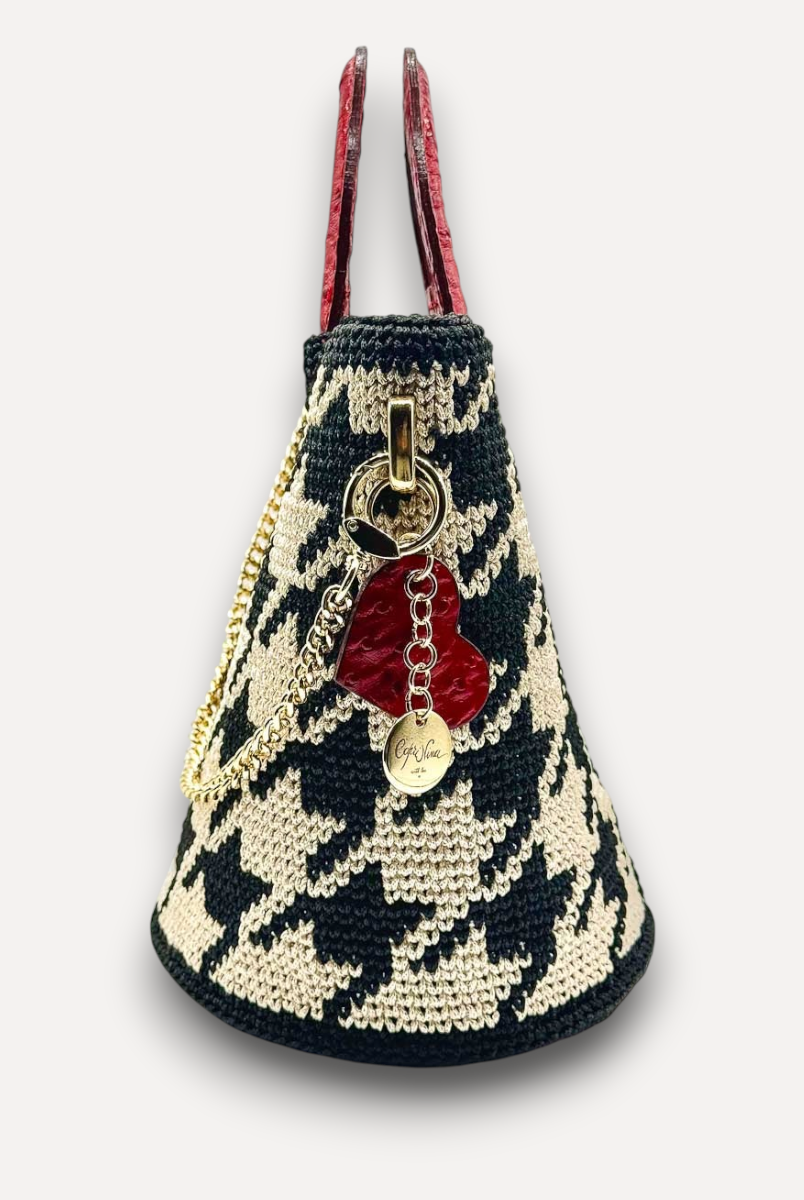 Borsa CapriNina Dodie in crochet con motivo pied de poule nero e beige, manici in pelle rossa e ciondolo a cuore.