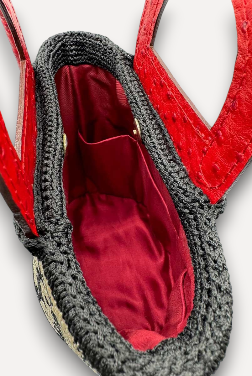 Interno della borsa CapriNina Dodie con fodera rossa, manici in pelle rossa e dettagli in crochet nero