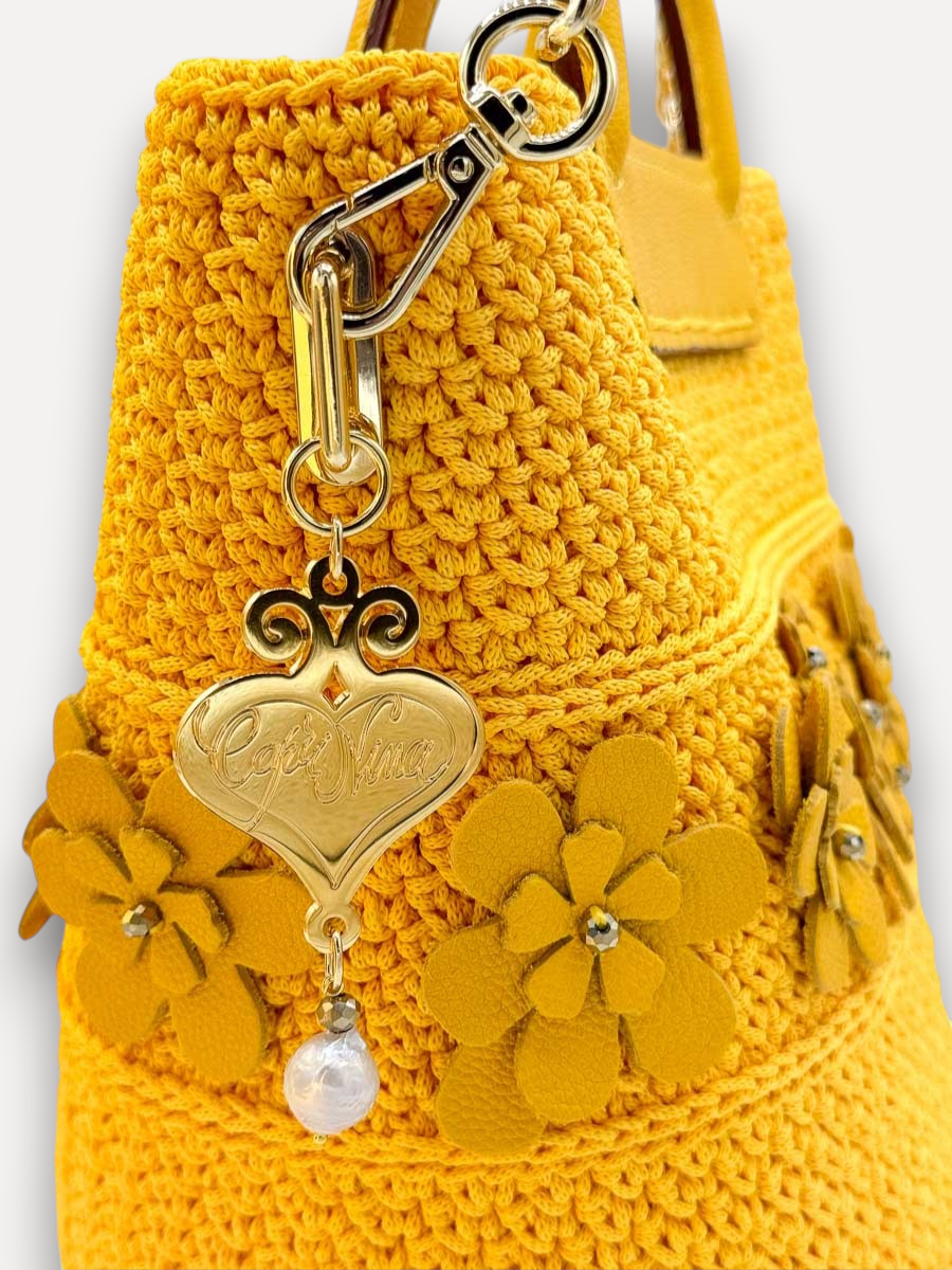 Borsa CapriNina gialla all'uncinetto con fiori in pelle, manico superiore e ciondolo a cuore dorato con perla