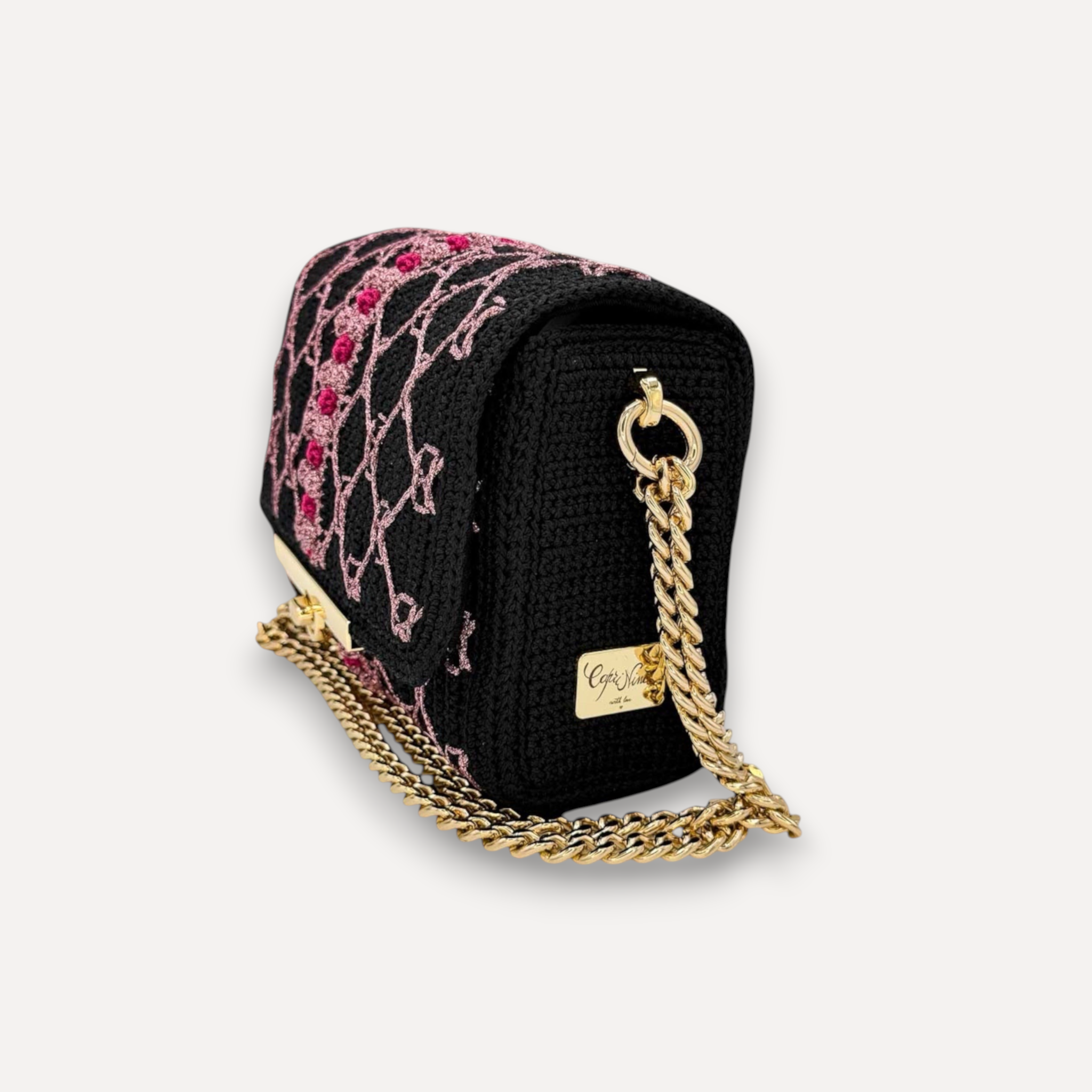 Borsa CapriNina fatta a mano all'uncinetto nera con ricami rosa, chiusura a incastro e catena dorata regolabile.
