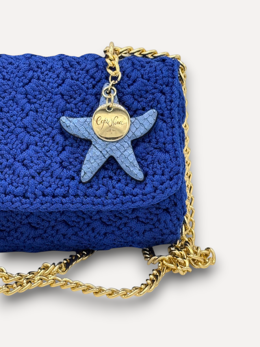 Borsa a tracolla CapriNina Ninetta piccola in crochet blu elettrico con catena dorata e ciondolo a stella marina
