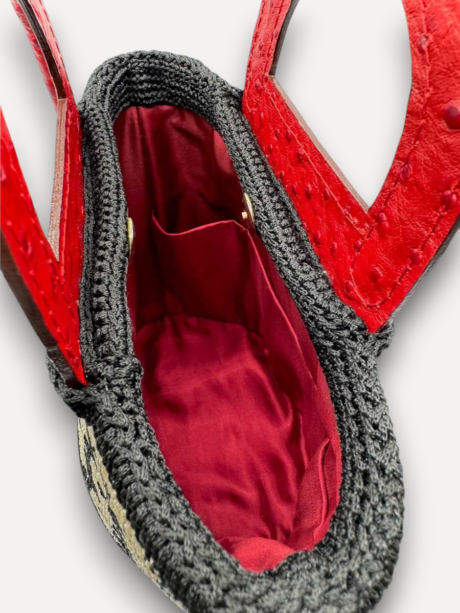 Interno della borsa CapriNina Dodie con fodera rossa, manici in pelle rossa e dettagli in crochet nero