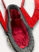 Interno della borsa CapriNina Dodie con fodera rossa, manici in pelle rossa e dettagli in crochet nero